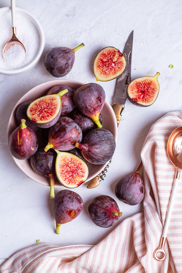 Red Figs in a pink bowl with a pink and white stripped napkin - Successful Client Shoot
